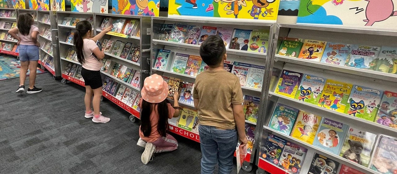 Children pick out books at a Scholastic Book Fair