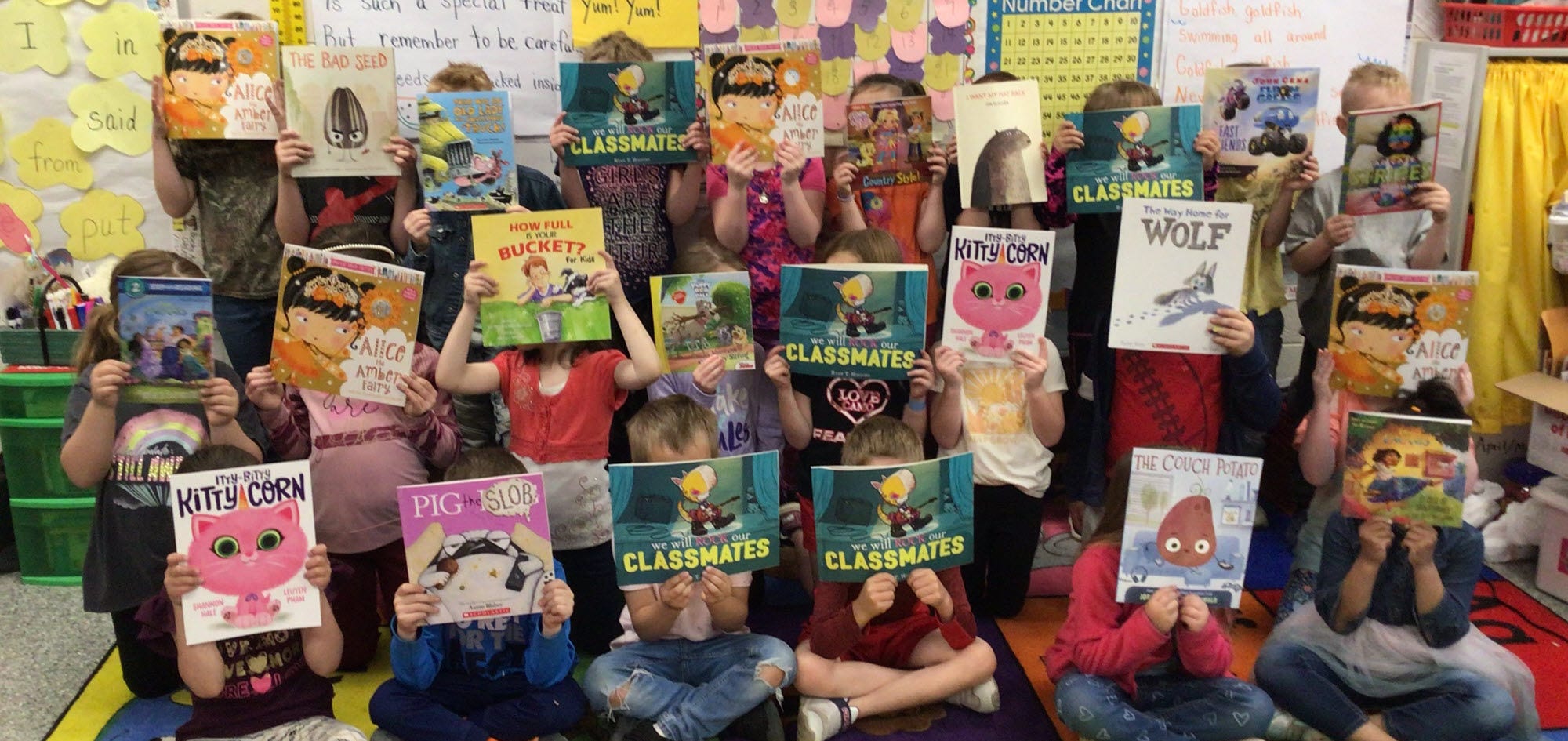 Children hold new books from Scholastic book fairs in rural elementary schools